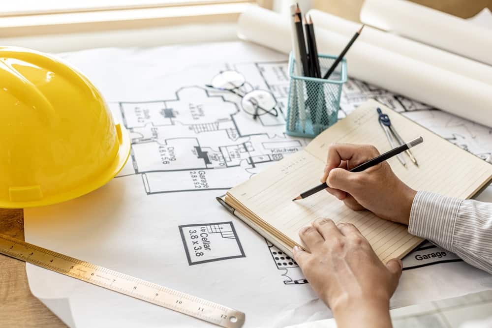 architects taking notes over blueprints